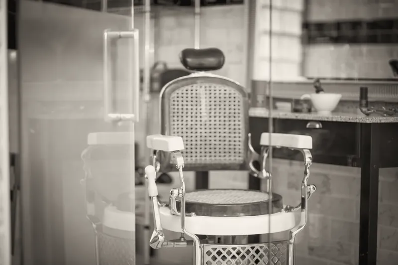 Antiguo sillón de barbero con respaldo de rejilla